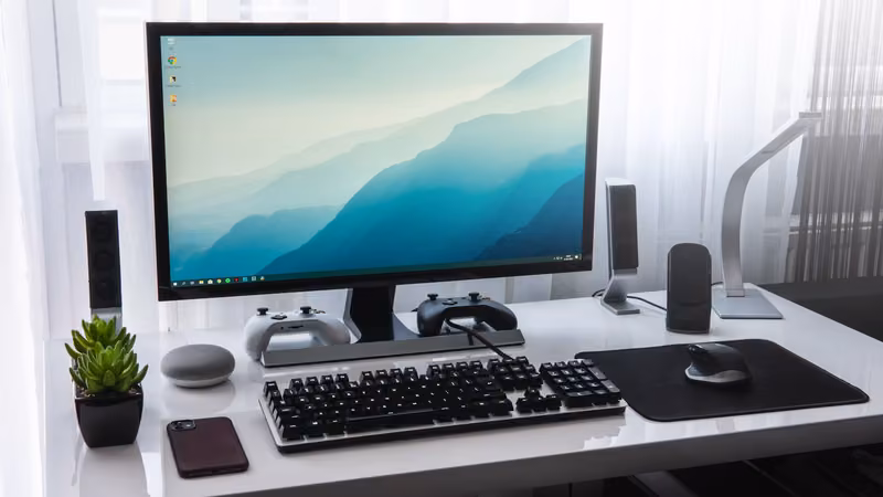 Estación de escritorio con monitor, teclado y controles de juego